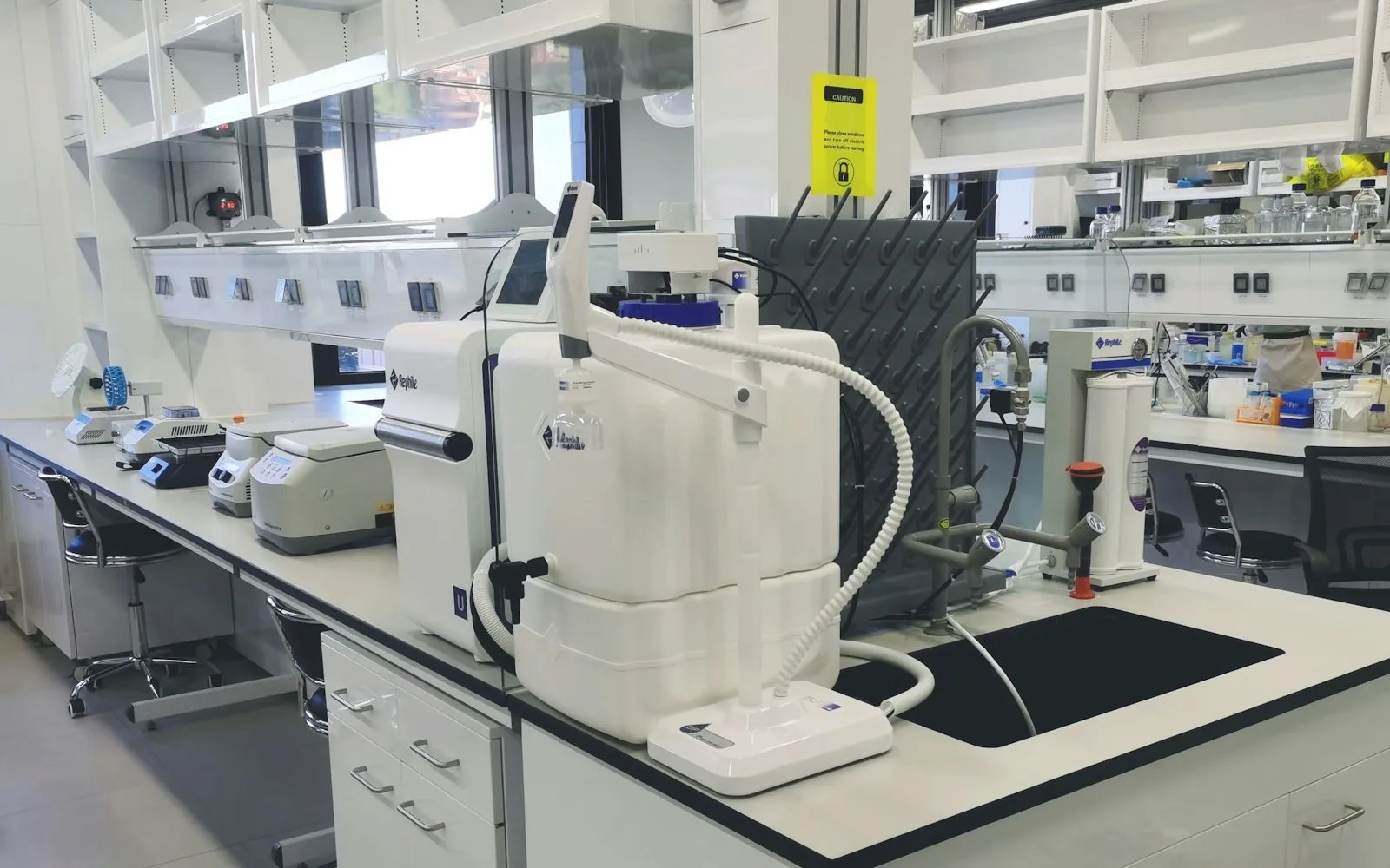 Wide view of a modern scientific laboratory with multiple workbenches and professional instrumentation