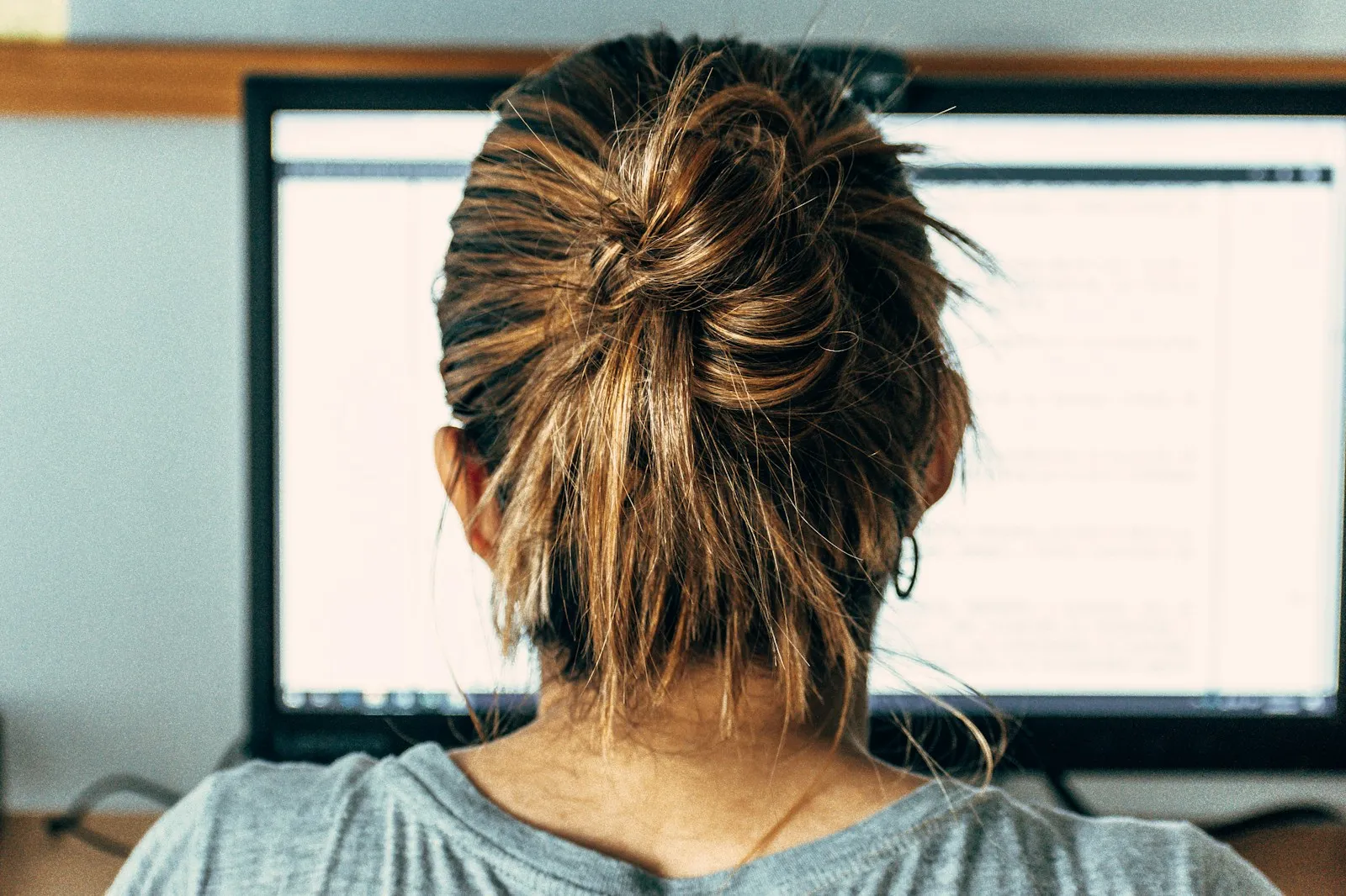 Person viewed from behind observing the computer screen in a dental practice